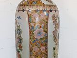 a vase that is sitting on a table in front of a white wall