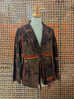 jacket on a mannequin stand in front of a woven wall