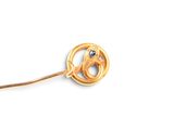 a gold pin with a bird on it on a white background