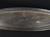a metal tray with a handle on a black surface