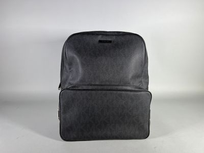 grey backpack sitting on a white surface with a white background