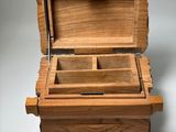an open wooden box sitting on top of a white surface