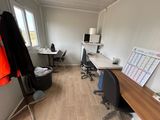 une pièce dans laquelle se trouvent deux bureaux et une chaise