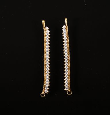 une paire de boucles d'oreilles en or et diamants sur fond noir