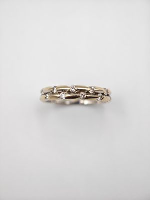 gros plan d'une bague en or avec des diamants sur fond blanc
