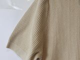 a close up of a sweater hanging on a hanger