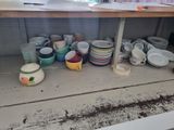 many cups and plates on the shelf in the kitchen