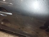 a close up of a car door handle with water droplets on it