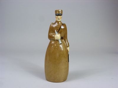 une figurine représentant une femme en robe et avec un chapeau