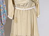 two women ' s dresses on a mannequin stand against a white wall