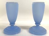 pair of blue glass vases sitting on top of a white table