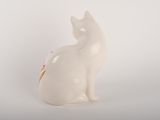 a white cat figurine sitting on a white surface
