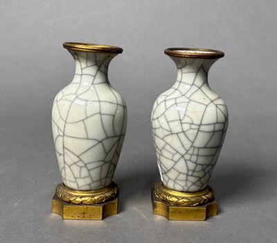 pair of white and gold vases sitting on top of a table