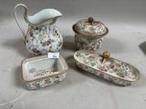 trois pièces de porcelaine exposées sur une table