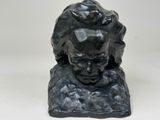 sculpture of a head of a woman on a rock on a white background