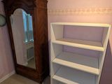 a white book shelf in the corner of a room