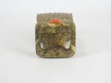 a small stone object with a red button on it