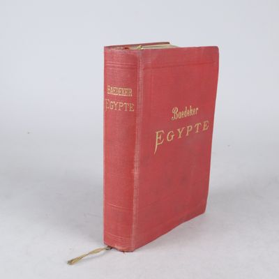 un livre rouge avec des inscriptions dorées sur une couverture blanche