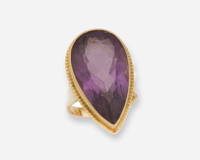 une bague en or ornée d'une pierre d'améthorate au centre