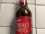 une bouteille de bière posée sur un sol carrelé