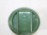 a close up view of a green button on a white surface