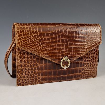 an image of a brown crocodile skin purse with a gold clasp
