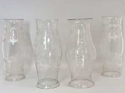 four glass vases sitting next to each other on a table