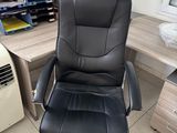 a black office chair sitting in front of a computer desk