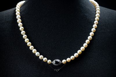 a close up of a pearl necklace on a mannequin mannequin