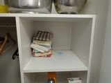 a small white shelf in the corner of a room