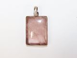 pendentif en verre rose muni d'une bélière en argent, sur fond blanc