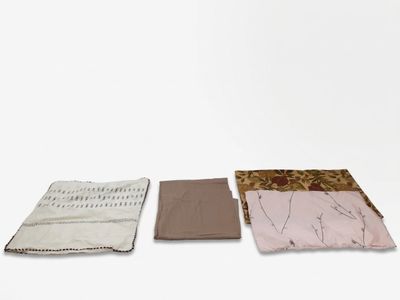 trois morceaux de tissu empilés les uns sur les autres sur une surface blanche