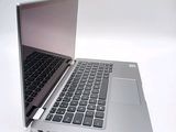 a silver laptop with a black keyboard on a white surface