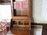 a wooden cabinet with a book shelf on top of it