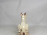 porcelain figurine of a cat sitting on a block on a white background