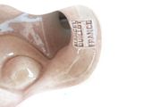 a figurine of a woman ' s face on a white surface