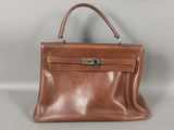 un sac à main en cuir marron sur fond gris