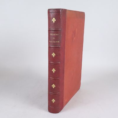 un livre rouge posé sur une table blanche