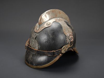un vieux casque orné d'une décoration métallique sur le côté