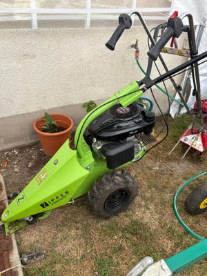 une tondeuse verte qui est posée dans l'herbe
