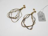 deux paires de boucles d'oreilles en or et en argent sur un fond blanc