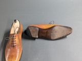 a pair of brown shoes sitting on top of a gray surface