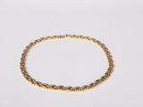 a gold chain bracelet with beads on a white background