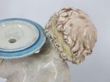 a figurine of a boy holding a blue and white plate