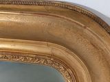 a gold frame with a mirror in it on the wall