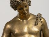 bronze statue of a young man holding a snake in his right hand