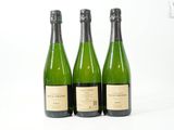trois bouteilles de vin posées les unes à côté des autres sur une surface blanche