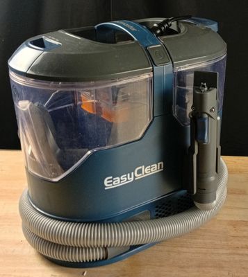un aspirateur posé sur une table en bois