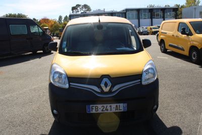 une camionnette jaune et noire garée sur un parking à côté d'autres véhicules