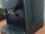a black coffee maker sitting on top of a wooden table